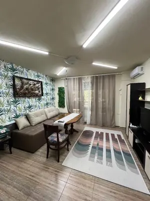a living room with a couch and a table at Апартамент Боги in Burgas City