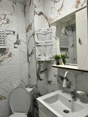 a white bathroom with a toilet and a sink at Апартамент Боги in Burgas City
