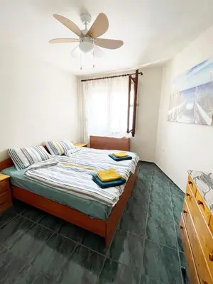 a bedroom with a bed and a ceiling fan at Cozy apartment at the heart of Burgas in Burgas City