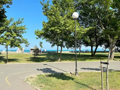 a street light in a park with the ocean in the background at Cozy apartment at the heart of Burgas in Burgas City