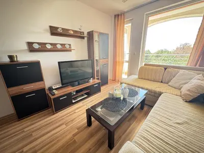 a living room with a couch and a tv at Линоляни in Pomorie