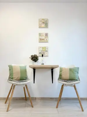 two chairs with pillows sitting next to a table at Sweet tiny house-central studio in Varna City