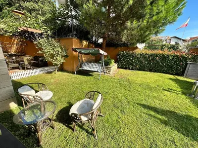 a yard with chairs and a table and a swing at Boulevard Sea Residenz 250 meter zum Sandstrand in Sunny Beach