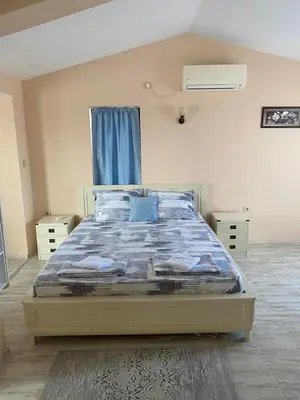 a bedroom with a bed with a blue comforter at Къща за гости DOSH in Sozopol