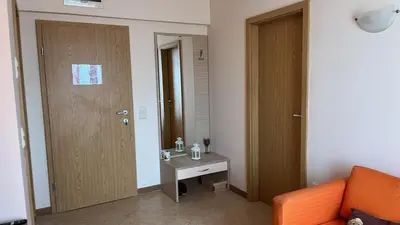 a room with an orange couch and a mirror at 1BD Apartment in Royal Sun Complex, Sunny Beach by Flat Mаnager in Sunny Beach