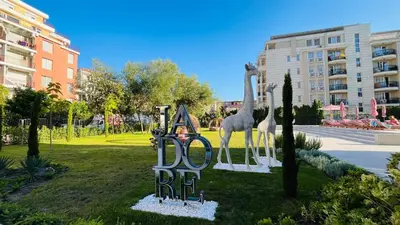a sign with giraffes on it in a park at JADORE Secret Garden Panoramic Studio in Sunny Beach