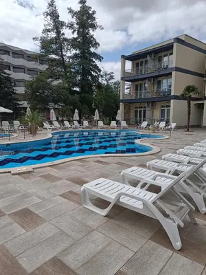 a swimming pool with lounge chairs and a hotel at Sol e Mar Sunny Beach in Sunny Beach