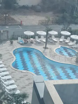 an overhead view of a swimming pool with chairs and umbrellas at Sol e Mar Sunny Beach in Sunny Beach