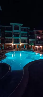 a large swimming pool in front of a building at night at Boulevard Sea Residenz in Sunny Beach