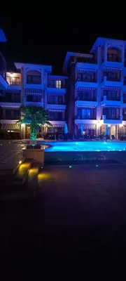 a building with blue lights in a parking lot at night at Boulevard Sea Residenz in Sunny Beach