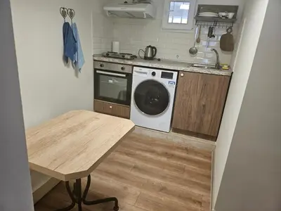 a kitchen with a washing machine and a table at Гарсониера в центъра на град Бургас in Burgas City