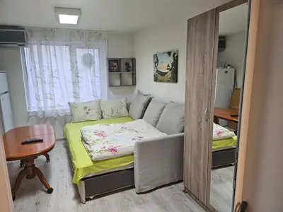 a small room with a bed and a mirror at Гарсониера в центъра на град Бургас in Burgas City