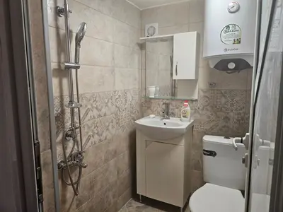 a bathroom with a toilet and a sink and a shower at Гарсониера в центъра на град Бургас l in Burgas City