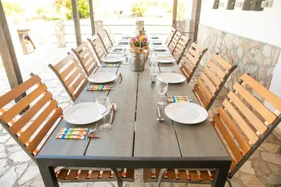 a long wooden table with plates and wine glasses at Luxury, private pool, sauna, beach! in Banya