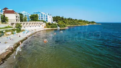 a group of people swimming in the water on a beach at Двустаен апартамент с морска панорама в Blue Bay Palace in Pomorie