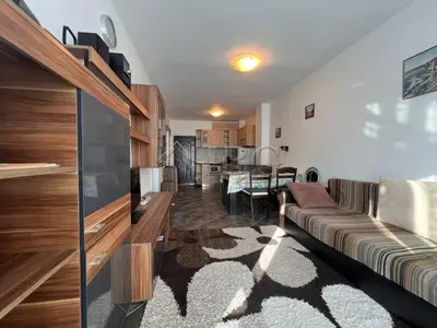 a living room with a couch and a kitchen at Двустаен апартамент с морска панорама в Blue Bay Palace in Pomorie