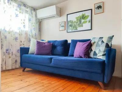 a blue couch sitting in a living room at KoLoNi Bright & Cosy LOFT in Varna City