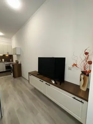 a living room with a flat screen tv on a white wall at Апартамент за нощувки и отдих in Burgas City