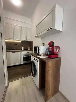 a kitchen with a washing machine and a microwave at Апартамент за нощувки и отдих in Burgas City