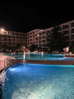 a large swimming pool in front of a building at night at Sarafovo ATLANTIS 58 in Burgas City