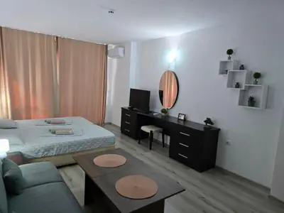 a bedroom with a bed and a table and a mirror at Sarafovo ATLANTIS 58 in Burgas City