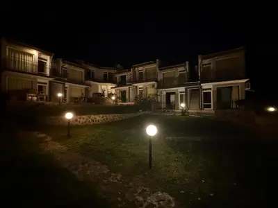 two lights in the grass in front of houses at night at Serenity Hill-Bulharsko U Nás in Sveti Vlas