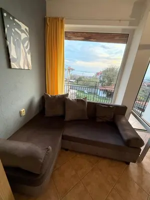 a couch in a room with a large window at Serenity Hill-Bulharsko U Nás in Sveti Vlas