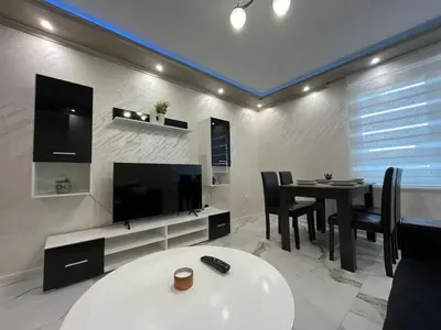a living room with a tv and a dining room table at Small Central Flat - Walk to Station & Cathedral in Varna City