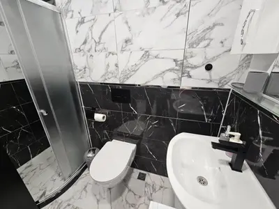 a bathroom with a white toilet and a sink at Small Central Flat - Walk to Station & Cathedral in Varna City