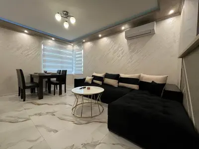 a living room with a couch and a table at Small Central Flat - Walk to Station & Cathedral in Varna City