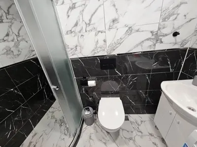 a bathroom with a white toilet and a sink at Small Central Flat - Walk to Station & Cathedral in Varna City