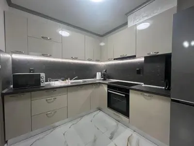 a kitchen with white cabinets and a black appliance at Small Central Flat - Walk to Station & Cathedral in Varna City