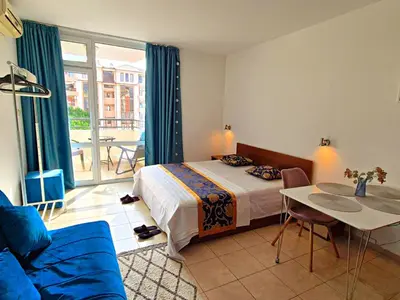 a bedroom with a bed and a table and a couch at complex Rose Residence Studio in Sunny Beach