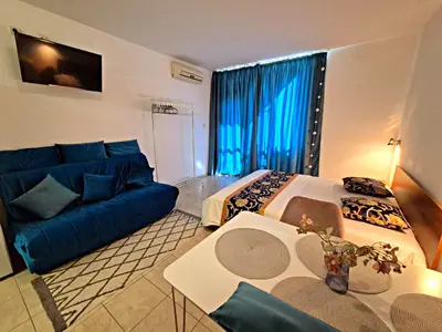 a living room with a blue couch and a blue sofa at complex Rose Residence Studio in Sunny Beach