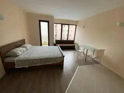 a bedroom with a bed and a table and a couch at Amber Beach in Sunny Beach