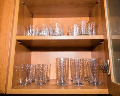 a bunch of glasses sitting on a shelf at Large 2 bedrooms Flat - TOP Center - in front of the Beach in Burgas City