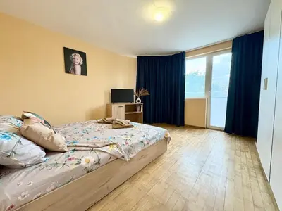 a bedroom with a large bed with blue curtains at Varna Thermae Loft in Varna City