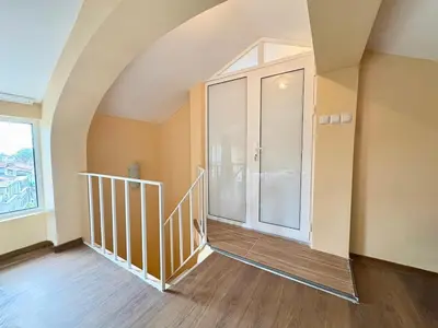 an empty room with a staircase and a large window at Varna Thermae Loft in Varna City