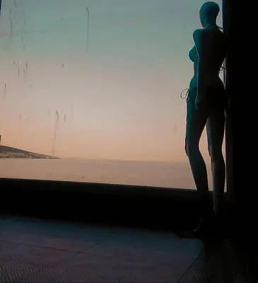 a woman standing in a window looking at the ocean at Seafront Luxury Studio with Panoramic Sea View, Sunny Beach in Sunny Beach