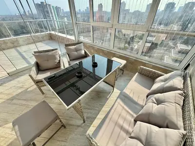 a living room with a table and chairs on a balcony at SeaSky SmartHome-Penthouse with private Parking in Burgas City
