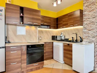 a kitchen with wooden cabinets and a white appliance at SeaSky SmartHome-Penthouse with private Parking in Burgas City
