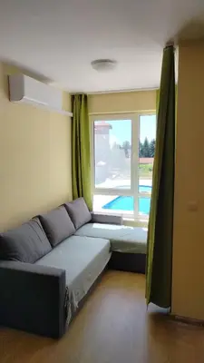 a living room with a couch and a window at Apartment Photinia in Byala