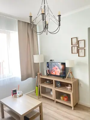 a living room with a tv and a table at Nearby the Sea- Elegant Retreat in Varna in Varna City
