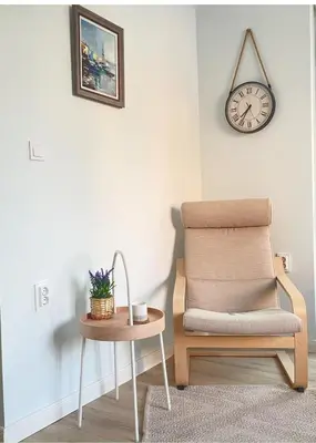 a chair and a table with a clock on the wall at Nearby the Sea- Elegant Retreat in Varna in Varna City