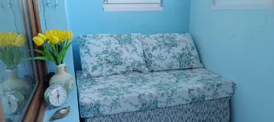 a chair in a room with flowers and a clock at Wild lakes home in Burgas City