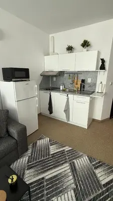 a living room with a kitchen with white cabinets at Atlantis Resort in Burgas City
