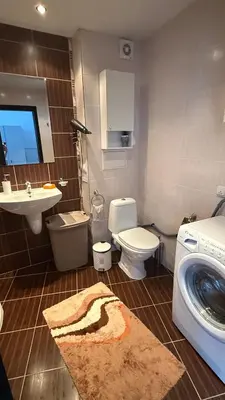 a bathroom with a toilet and a sink and a washing machine at Atlantis Resort in Burgas City