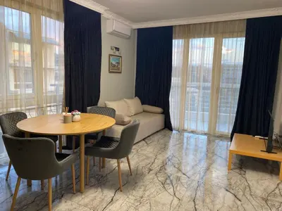 a living room with a table and a couch at Sol e Mar Deluxe Apartment in Sunny Beach