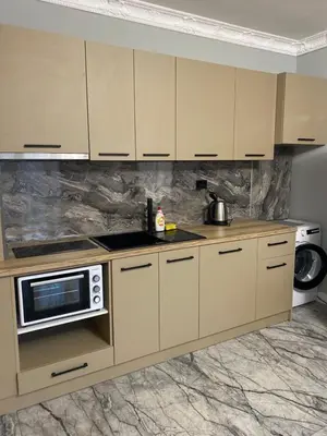 a kitchen with white cabinets and a microwave at Sol e Mar Deluxe Apartment in Sunny Beach