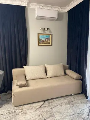 a couch in a living room with blue curtains at Sol e Mar Deluxe Apartment in Sunny Beach